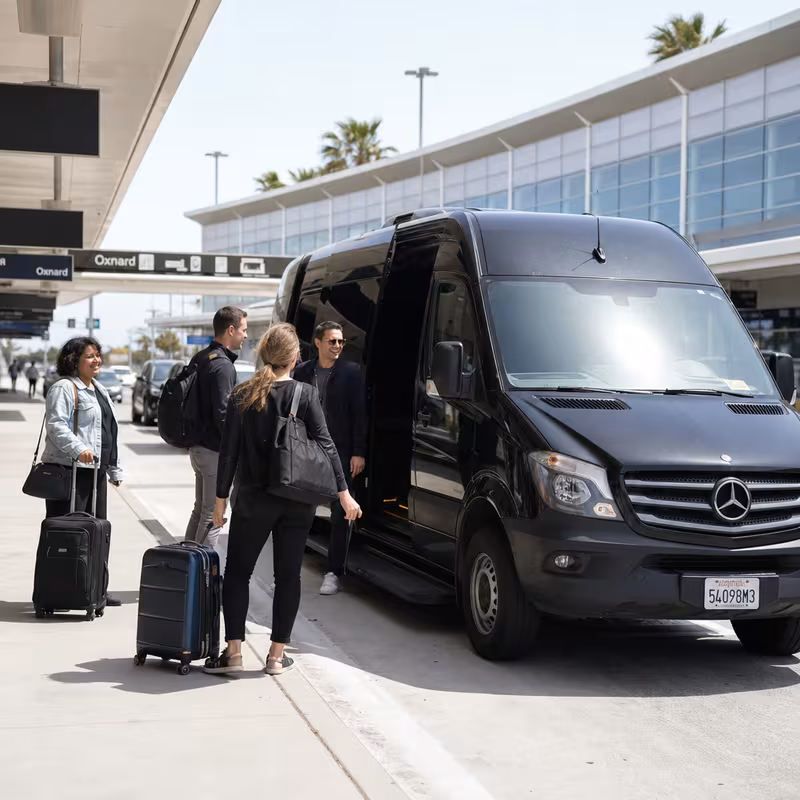 Group boarding a white charter bus for Airport Transportation transportation in Oxnard