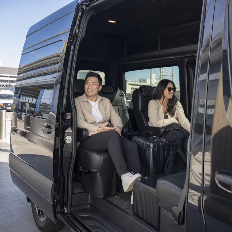 Passengers loading luggage while boarding an Oxnard group shuttle