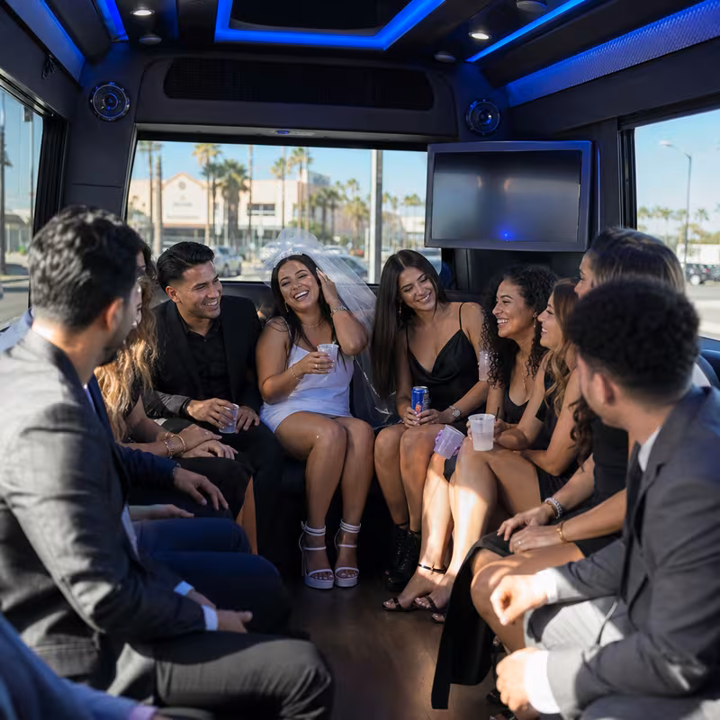Party bus interior with wraparound leather seating and LED lighting in Oxnard