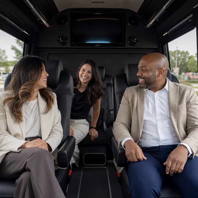 Group boarding a white charter bus for Corporate Transportation transportation in Oxnard