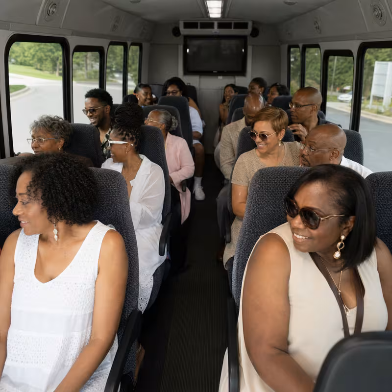 Group boarding a white charter bus for Private Event Transportation transportation in Oxnard