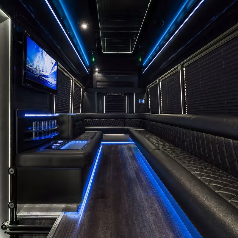 Party bus interior with wraparound leather seating and LED lighting in Oxnard