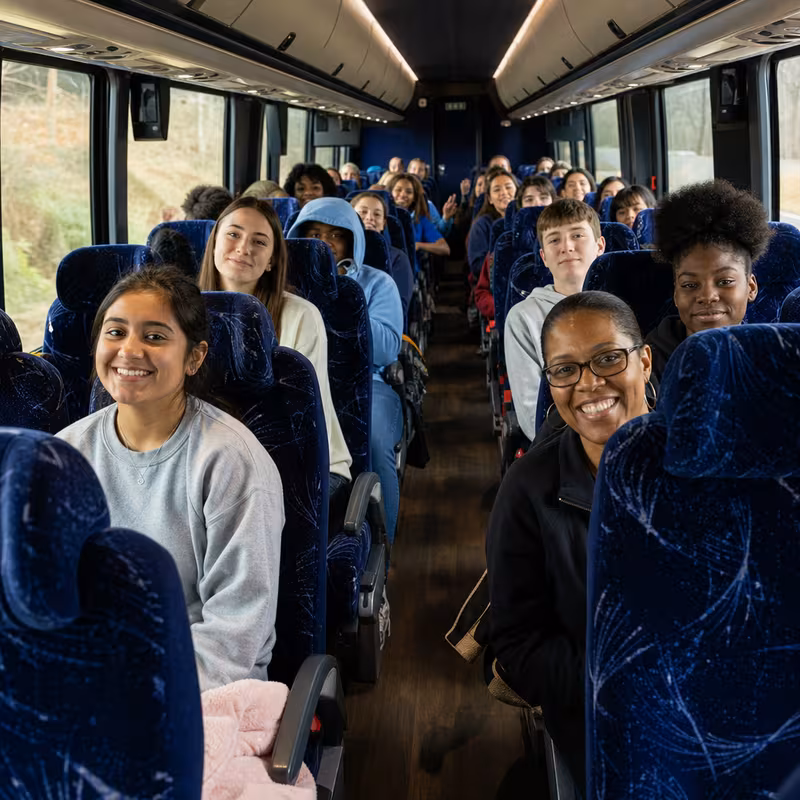 Group boarding a white charter bus for School Transportation transportation in Oxnard