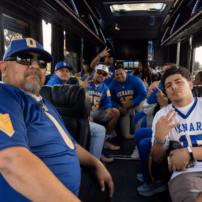 Group boarding a white charter bus for Sporting Event Transportation transportation in Oxnard