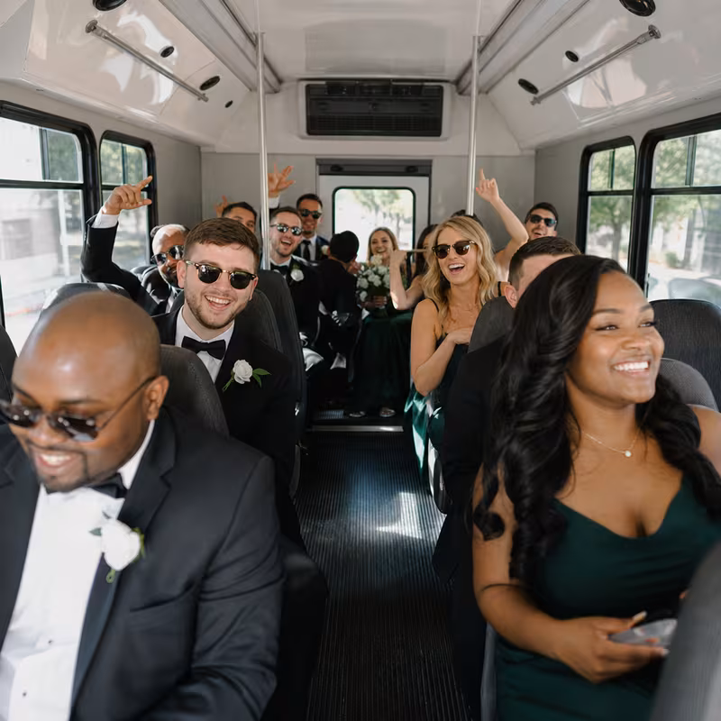 Group boarding a white charter bus for Wedding Transportation transportation in Oxnard